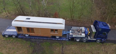 Tiny house on trailer on back of low rider truck tray